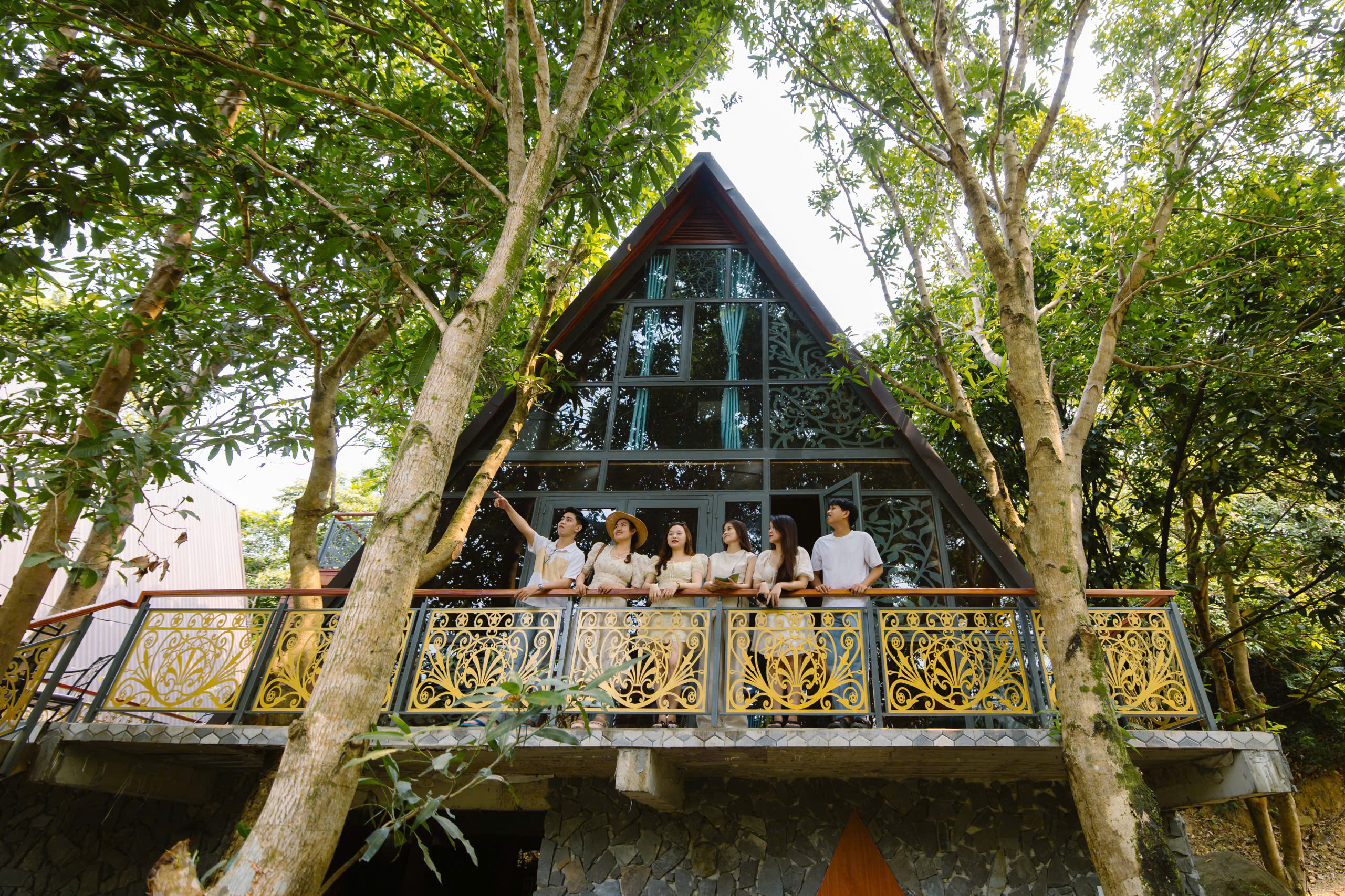 Guests on the balcony of an A-frame house at Suoi Luong