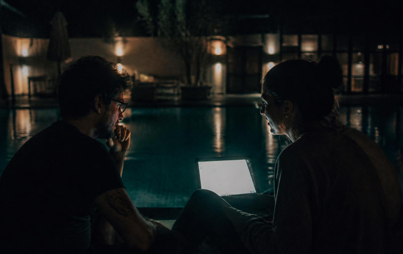 Two builders talking late at night by the pool